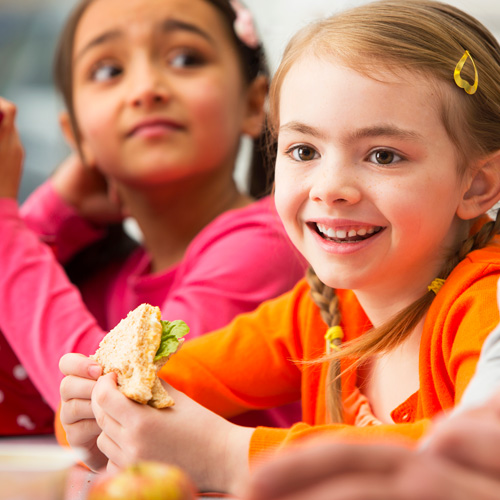 Two young girls eating lunch together